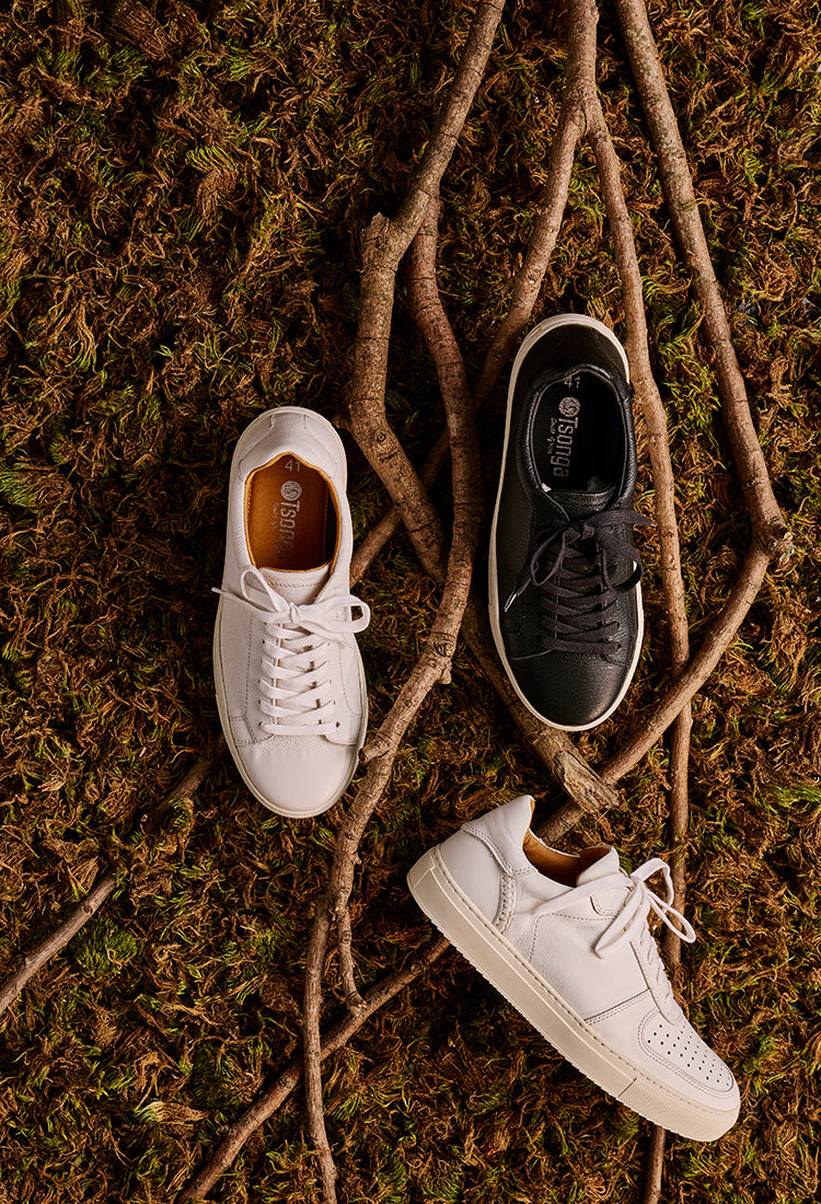 Three pairs of sneakers on a textured brown surface