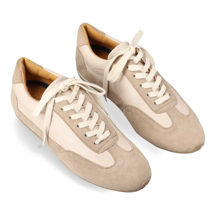 A pair of low-top casual sneakers in beige and cream suede and leather, featuring cream laces, shown on a white background.