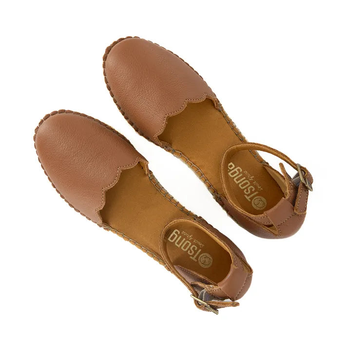 Pair of brown sandals with scalloped edges on a white background