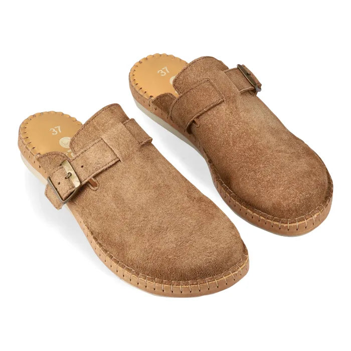Pair of brown suede mules with buckles on a white background
