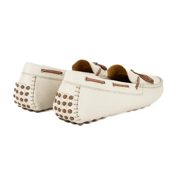 Pair of cream-colored loafers with brown accents on a white background