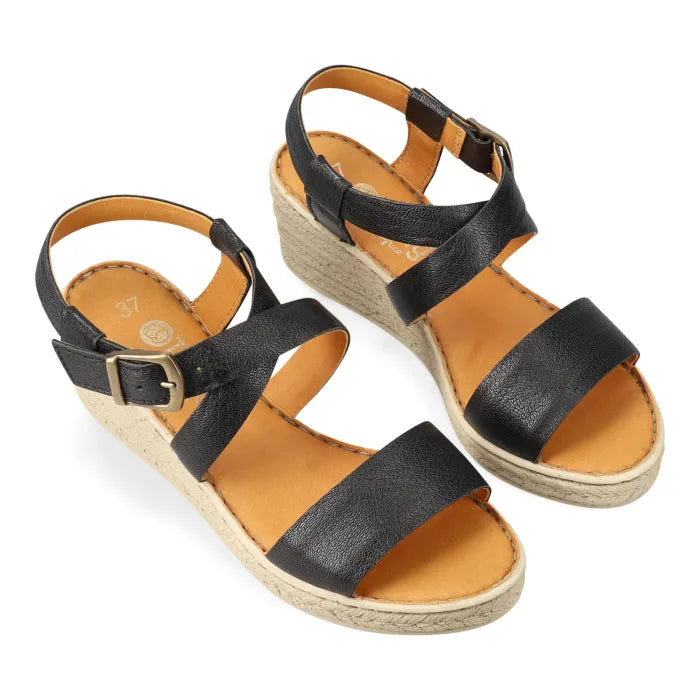 Black sandals with tan soles on a white background