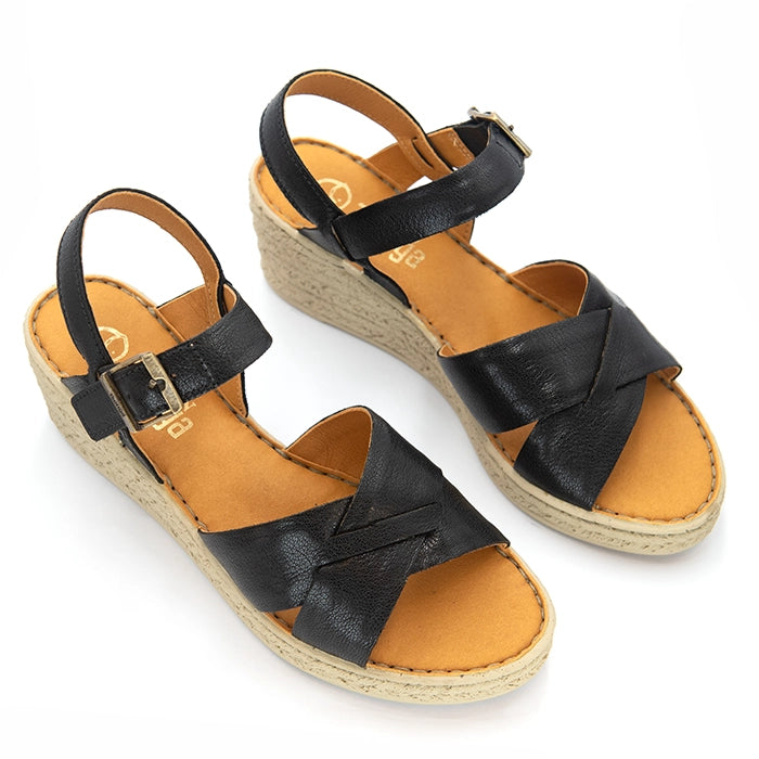 A pair of women's wedge sandals with black leather straps and a tan insole, shown on a white background.