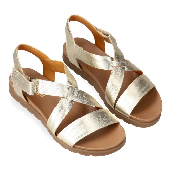 Gold sandals with brown soles on a white background