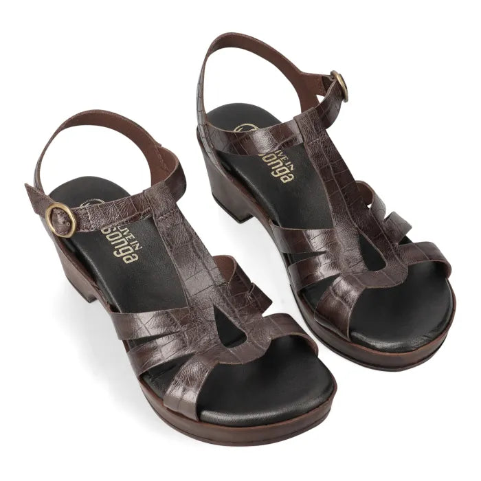 A pair of dark brown leather slingback wedge sandals with cutout straps and a textured finish, shown on a white background.