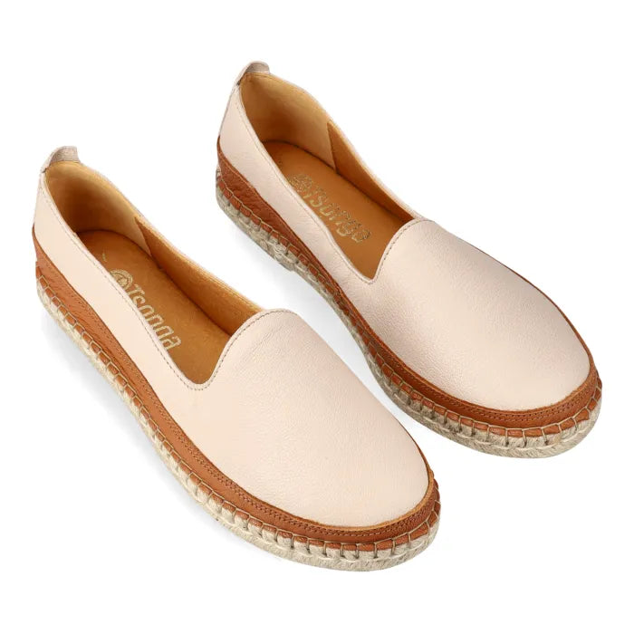Pair of beige espadrille shoes with brown accents on a white background