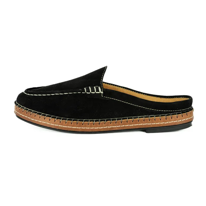 Black slip-on shoe with brown sole on a white background