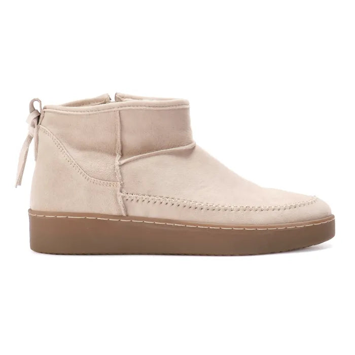 Beige ankle boot with brown sole on a white background