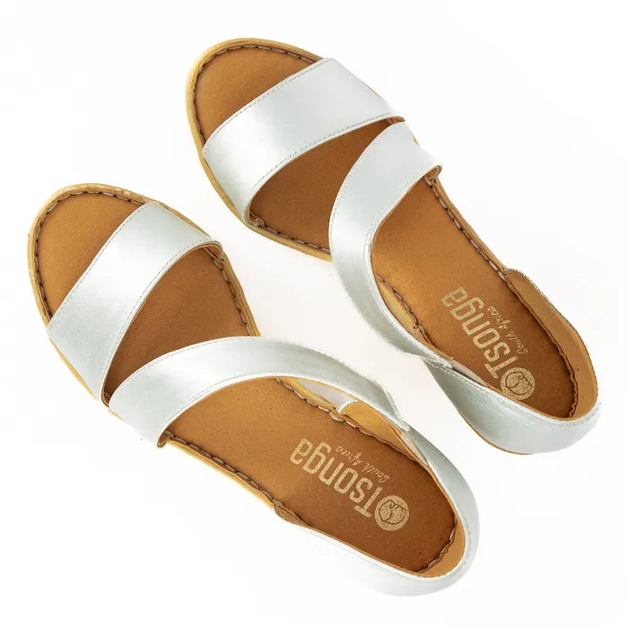 Pair of silver sandals with brown soles on a white background