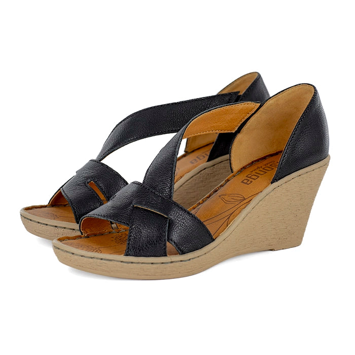 Black wedge sandals with a tan sole on a white background