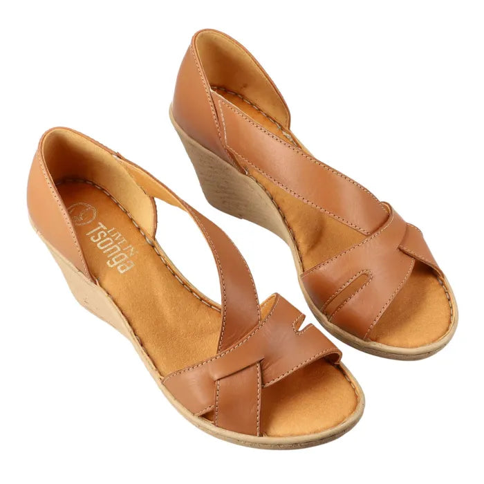 A pair of tan leather wedge sandals with criss-cross straps and open toes, displayed on a clean white background.