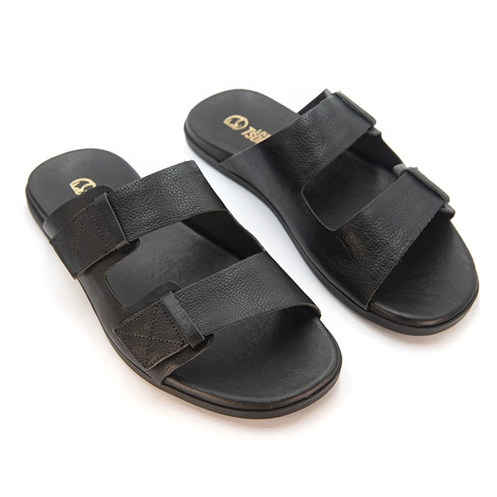 A pair of black double-strap slide sandals with a pebbled leather texture, shown on a clean white background. The brand logo 'Tsonga' is printed in gold on the heel of the footbed.