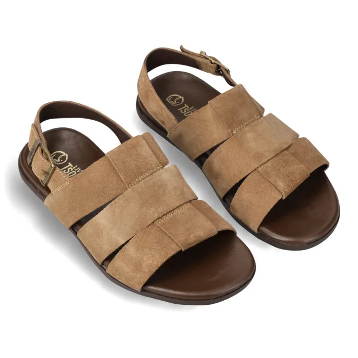 A pair of men's slide sandals in tan suede with dark brown soles and adjustable ankle straps, shown on a white background.