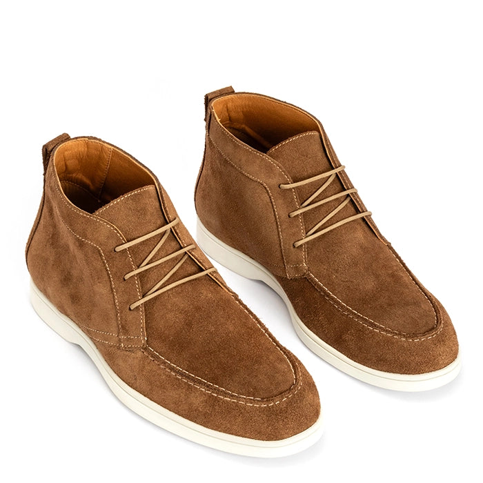 A pair of men's brown suede chukka boots with beige laces and white soles, shown from a three-quarters angle on a white background.