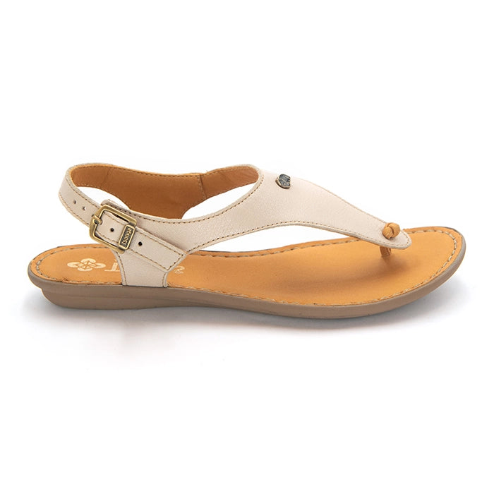 A single women's flat thong sandal in light beige leather with a tan footbed and sole, featuring a small silver-tone decorative stud on the strap and a gold-tone buckle on the adjustable ankle strap.