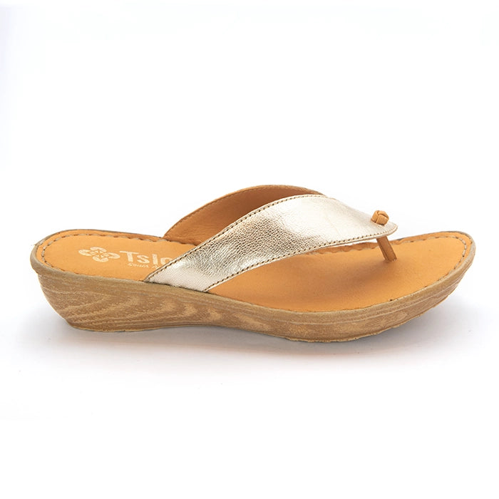 A single women's thong sandal with a metallic gold strap, tan leather footbed, and a light brown wood-look wedge heel, shown from a side profile on a white background.