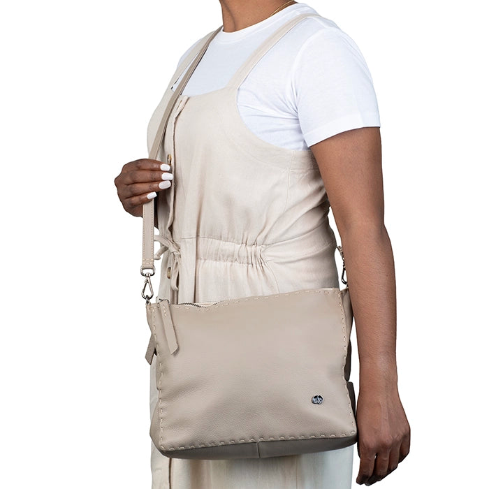 Person wearing a beige apron over a white shirt with a matching bag.
