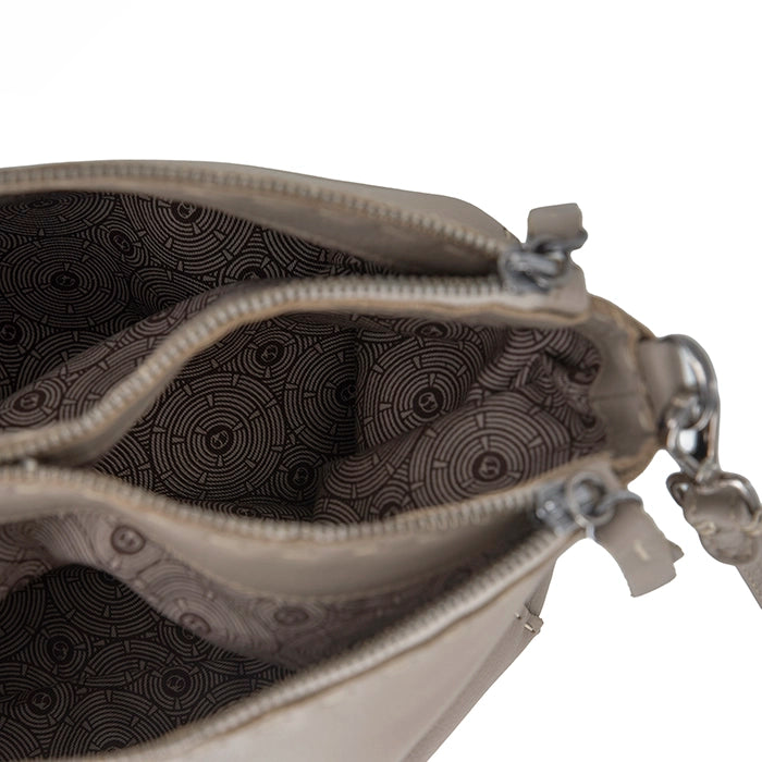 Close-up of a beige handbag with a zipper, showing the interior pattern.