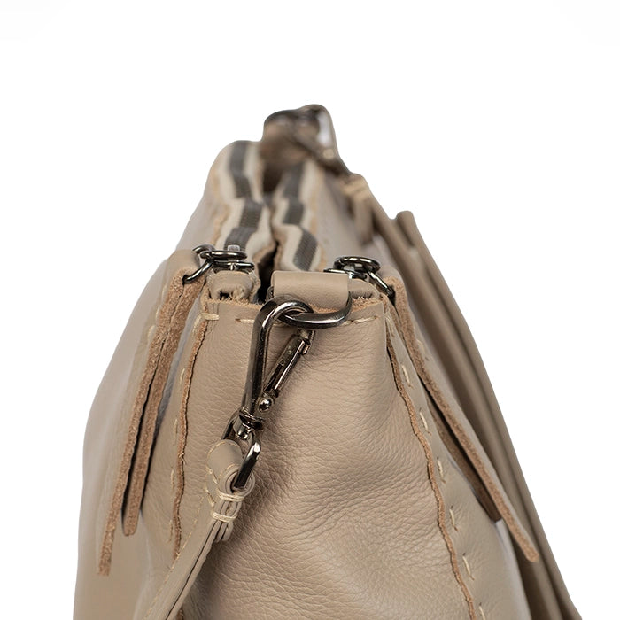 Close-up of a beige handbag with a metal clasp on a white background