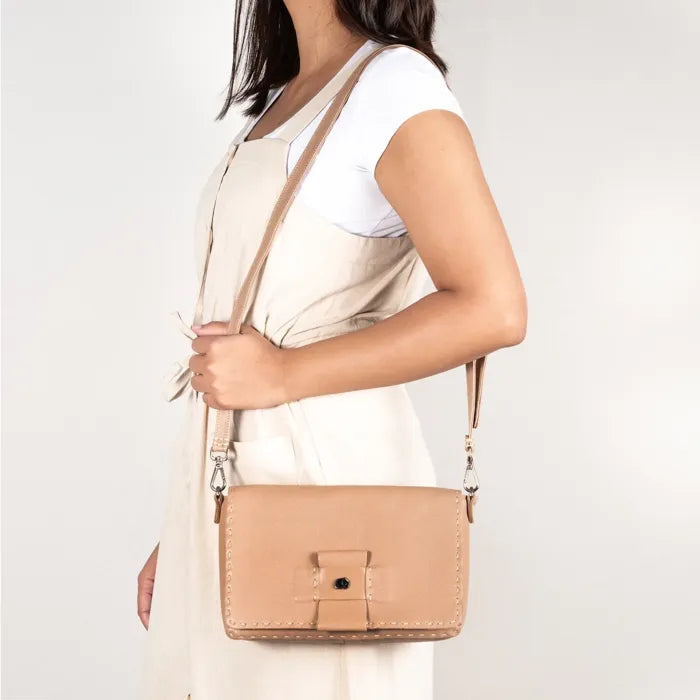 Person wearing a beige handbag.