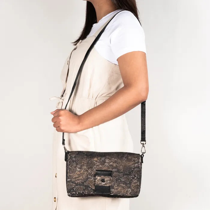 Person holding a textured black handbag against a white background