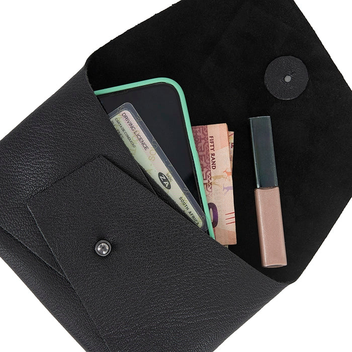 Open black leather clutch displaying contents including a smartphone, money, ID cards, and lip gloss, with beige suede interior and front pocket.
