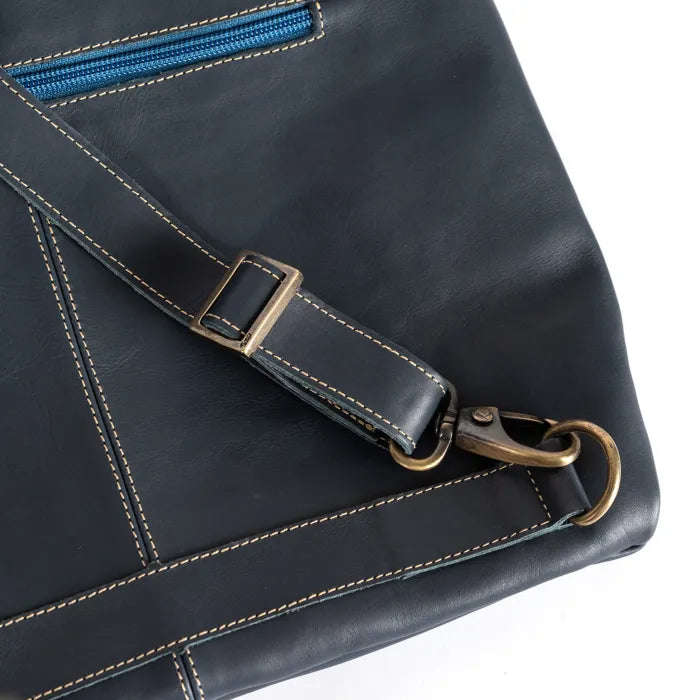 Black leather bag with a blue zipper and brass hardware on a white background
