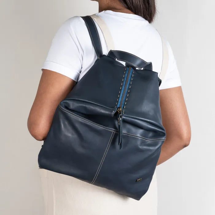 Person wearing a blue backpack against a plain background