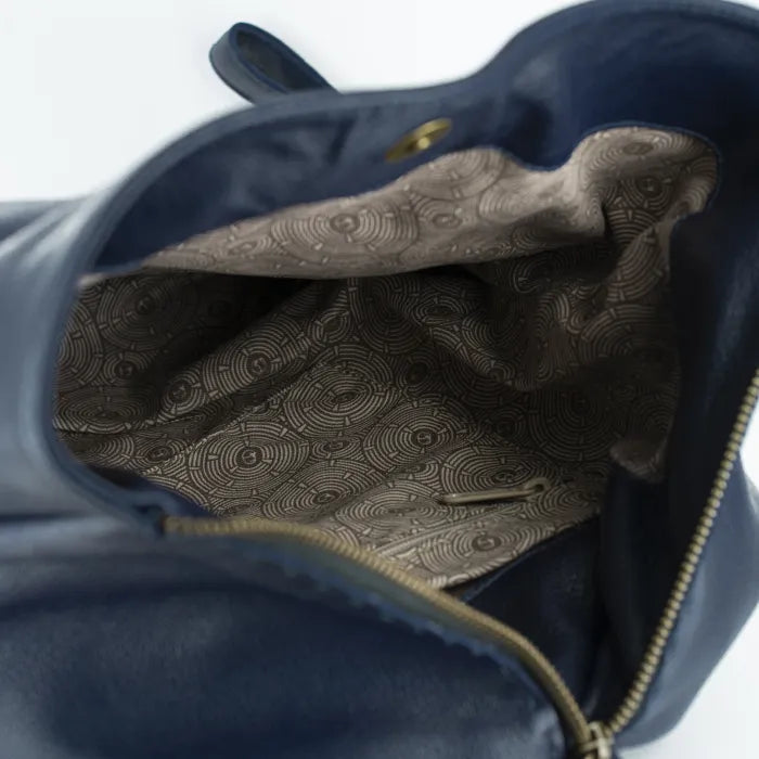 Close-up of a blue leather bag with a patterned interior lining.