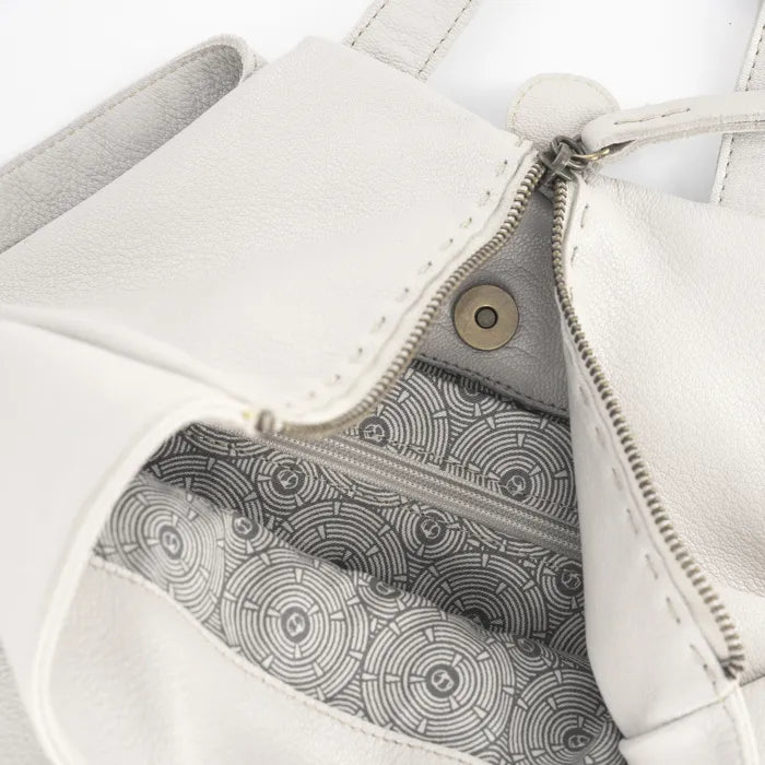 Close-up of a cream leather bag with a zipper, showing the interior pattern.