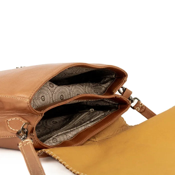 Tan leather handbag with patterned interior on a white background