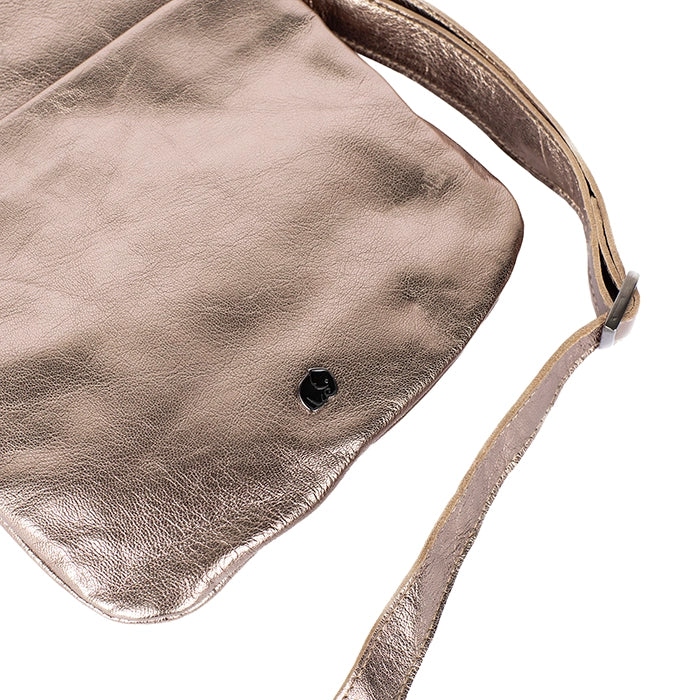 Close-up of a metallic gold handbag with a strap on a white background