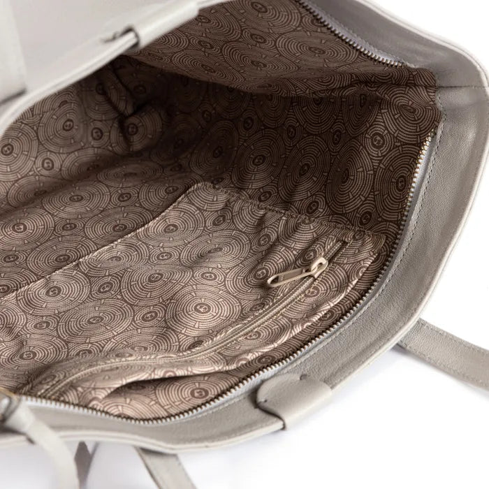 Close-up of a grey handbag with a patterned interior on a white background