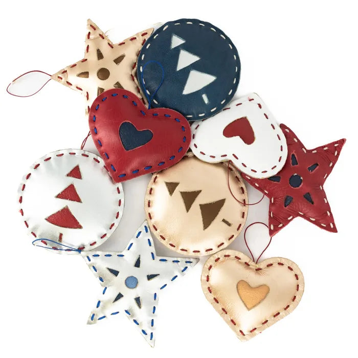Decorative items including stars, hearts, and circles with embroidered patterns on a white background.
