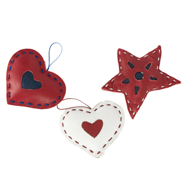 A collection of small, leather Christmas tree accessories shaped like stars andhearts with hand lacing detail.
