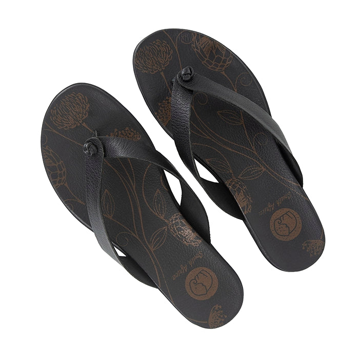 Pair of black flip-flops with floral patterns on a white background