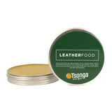 Tin of leather food with green lid and gold base on a white background