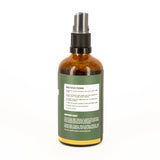 Brown spray bottle with green label on a white background
