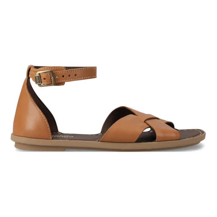 A tan leather flat sandal with an ankle strap and buckle, shown in a side profile on a white background.
