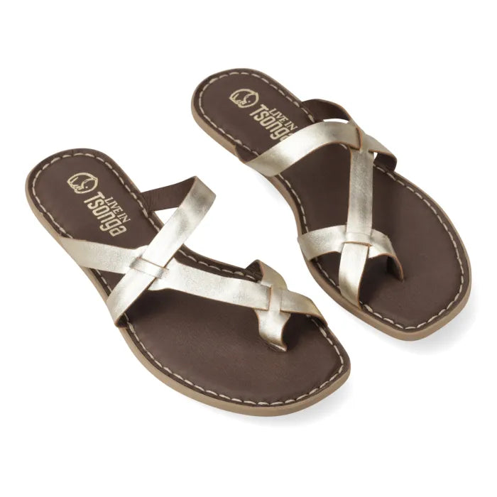 A pair of metallic gold criss-cross thong sandals with dark brown footbeds, shown on a clean white background.