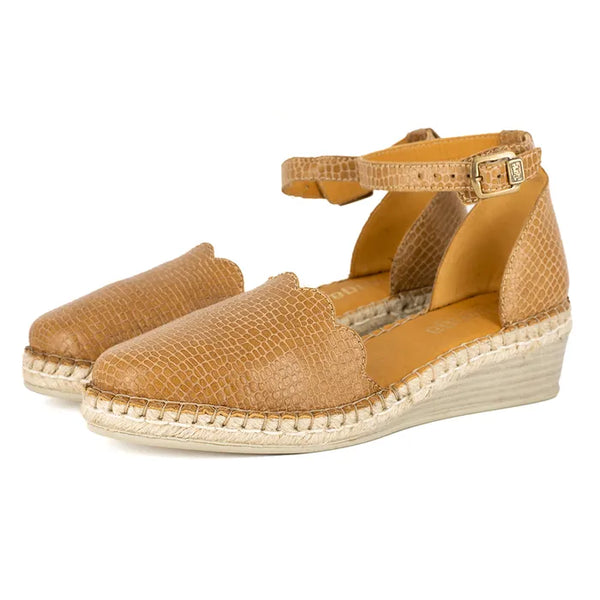 Pair of tan wedge sandals with espadrille sole on a white background