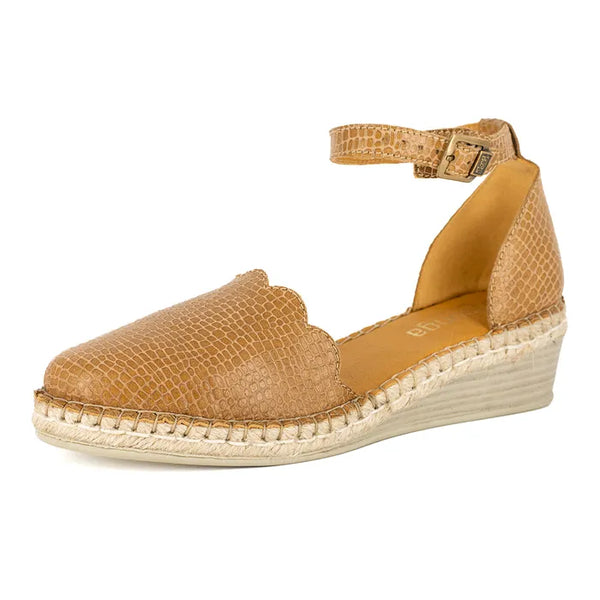 Tan wedge sandal with textured strap on a white background
