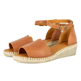 Tan wedge sandals with espadrille sole on a white background