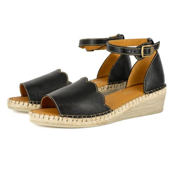 Black wedge sandals with espadrille sole on a white background