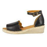Black wedge sandal with tan sole on a white background