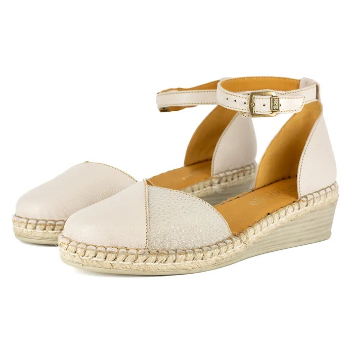 Pair of cream-colored wedge sandals with a white background