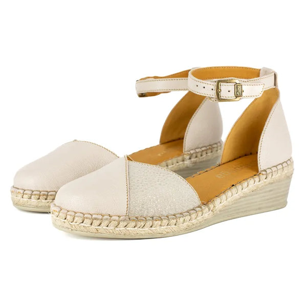 Pair of cream-colored wedge sandals with a white background