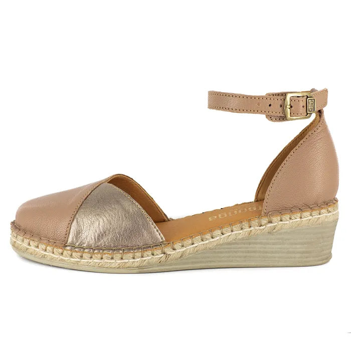 Beige and metallic shoe on a wedge sole on a white background
