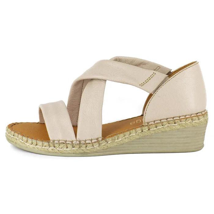 Beige wedge sandal with criss-cross straps on a white background