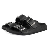 Black sandals with silver buckles on a white background